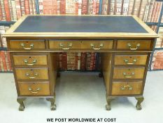 A mahogany twin pedestal desk with leather inset top raised on ball and claw feet (W122 x D66 x