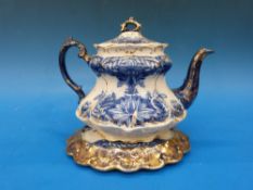 A teapot and stand marked SJB