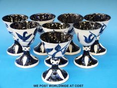 A set of eight Wilfred Gibson blue and white ceramic goblets with bird decoration