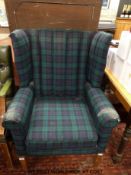 A tartan upholstered wing backed chair