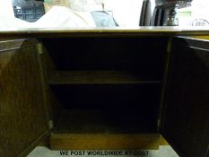 An oak sideboard cupboard with panelled doors to base and glazed top section (H192cm x W152 x