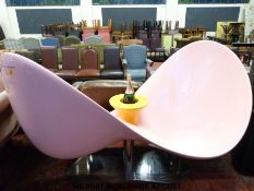 A Veuve Clicquot loveseat by Karim Rashid in pink fibreglass raised on a chrome pedestal base