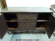 A brass inlaid and carved Northern Indian sideboard with four straight drawers flanked by cupboards
