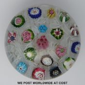 Clichy chequer glass paperweight with 18 various canes including a pink and green rose all on a bed