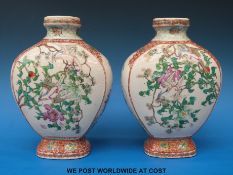 A pair of Japanese Kutani vases decorated with birds amongst flowers and foliage on a white ground