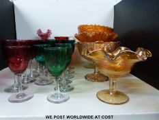 Sixteen various cranberry and blue glass wine glasses together with a collection of carnival glass,