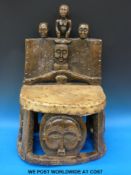 A Chokwe Chief's chair carved with typical Chokwe faces and figures with hide and stud decoration
