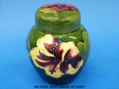 A Moorcroft ginger jar and cover in Hibiscus pattern on a green ground (11cm tall)