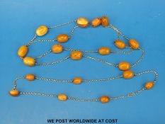 An amber and yellow metal necklace together with a similar necklace