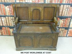 An oak monk's bench with figural lion arms (width 96cm)