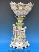 A late 19thC /20thC continental figural comport with applied flower and fruit decoration