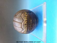 A vintage leather football with gilt lettering 'Cheltenham Town' in perspex display case