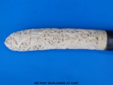 A Balinese ivory knife with ornately carved figural handle and white metal collar (36cm long)