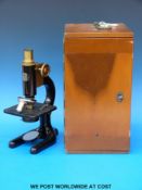 A cased microscope by C Baker with a selection of lenses
