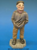 A Royal Worcester figure of a man with hands in pockets and a cap (14cm tall)
