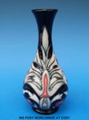 A Moorcroft vase with stylised floral decoration on a black ground (17cm tall)