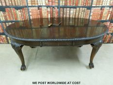 A Victorian or early 20thC carved mahogany table with extra leaf and winder raised on ball and claw