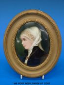 An KPM or Berlin ceramic painted oval plaque of a girl with white head-dress,