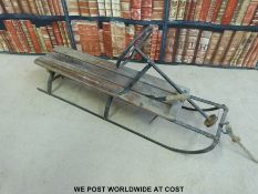 A vintage toboggan /sled with steering and brake