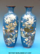 A pair of Japanese Meiji period cloisonné vases with floral decoration on a blue ground and borders
