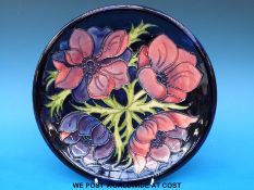 A Moorcroft charger in Anemone pattern on a blue ground (26cm diameter)