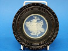 A 19thC Jasperware plaque decorated with dancing maidens in glazed hardwood frame.