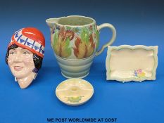 A collection of Clarice Cliff to include a jug, a face mask,