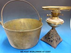 A heavy brass cooking pan and a brass oil lamp with pieced decorated stand