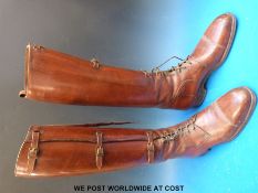 An early 20thC pair of vintage brown leather lace-up and buckled riding boots with 