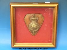 A framed 19thC military horse brass mounted on leather
