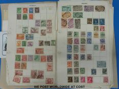 A folder of all world stamps on loose album pages and small quantity of postcards