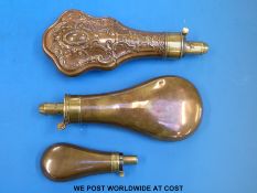 Three copper powder flasks with brass mounts,