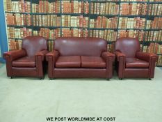 A red leatherette Art Deco style three piece suite