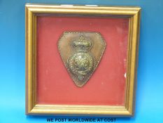 A framed 19thC military horse brass mounted on leather