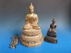 A collection of three Buddhas including a large Burmese example example sitting on a stylised lotus
