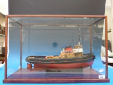 A 1:48 scale model tug boat in glass case.