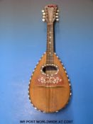 A cased mandolin by Luigi Poppi Palmero decorated with tortoiseshell and mother of pearl inlay.