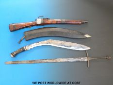 An Eastern style gun, kukri, a sword and a folding knife.