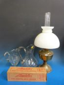 An oil lamp with glass shade and two large glass jugs