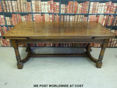 A large oak extending dining table with shaped and moulded stretchers (min length 198, max 290cm,