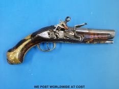 A flintlock overcoat pistol with visible Roman type lock, engraved and inlaid brass mounts,