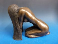 A bronze coloured figure of a kneeling nude with long hair (height 24cm)