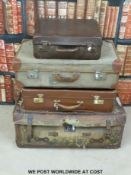 Four vintage leather and canvas suitcases, some with original shipping labels.