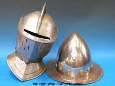 A reproduction knight's helmet together with another helmet.