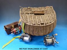 Vintage wicker fishing creel with Abu & Penn multipliers and an Abu closed faced reel.