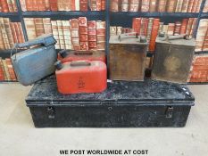 A metal trunk with vintage petrol cans