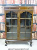 A glazed late 19th / 20th bookcase raised on ball and claw feet (W82 x D26 x H122cm)