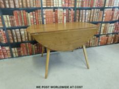 An Ercol light elm table and four chairs