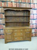 A late 19thC/early 20thC oak dresser having three drawers flanked by cupboard and drawer to each