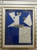 An autographed Bristol Rovers football shirt signed by 15 players, framed and glazed.